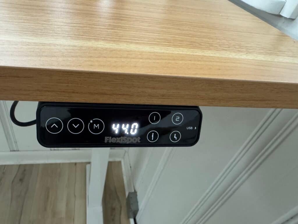 The LCD keypad on my FlexiSpot E7 Pro, showing height memory buttons, USB charging, and child-lock feature